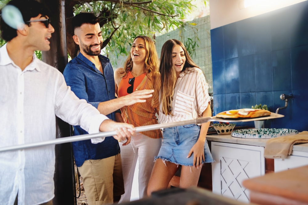 Groupoffriendshavefunpreparingpizzasandbakingthem | h3 outdoor design & construction