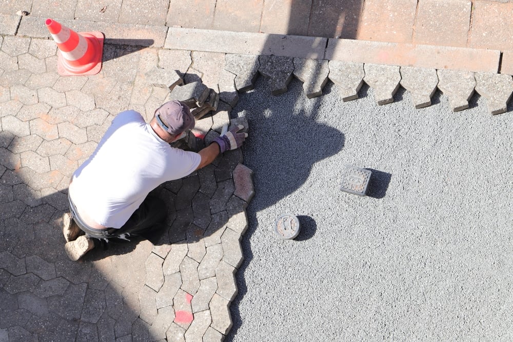 a Worker is Laying Paving Stones in Gravel